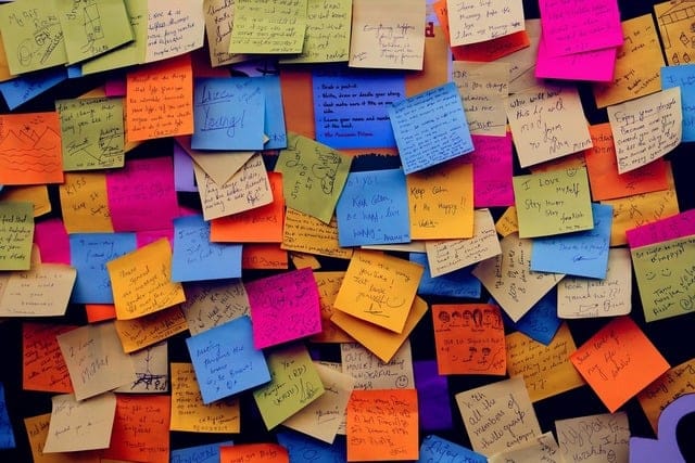 Dozens of colorful post-it notes, with writing on them 