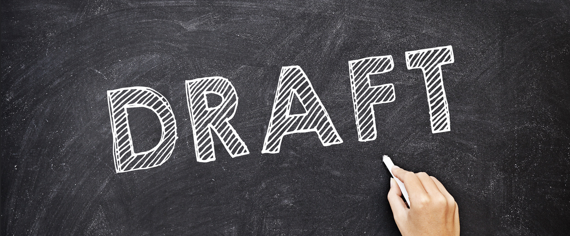 A chalkboard with the word Draft on it.  Below, a hand with a piece of chalk.