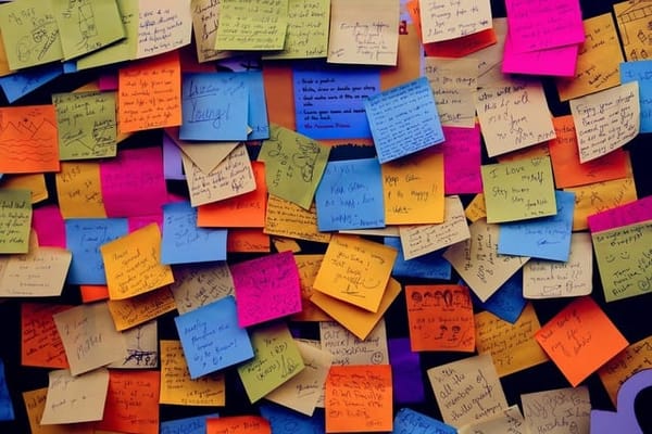 Dozens of colorful post-it notes, with writing on them 
